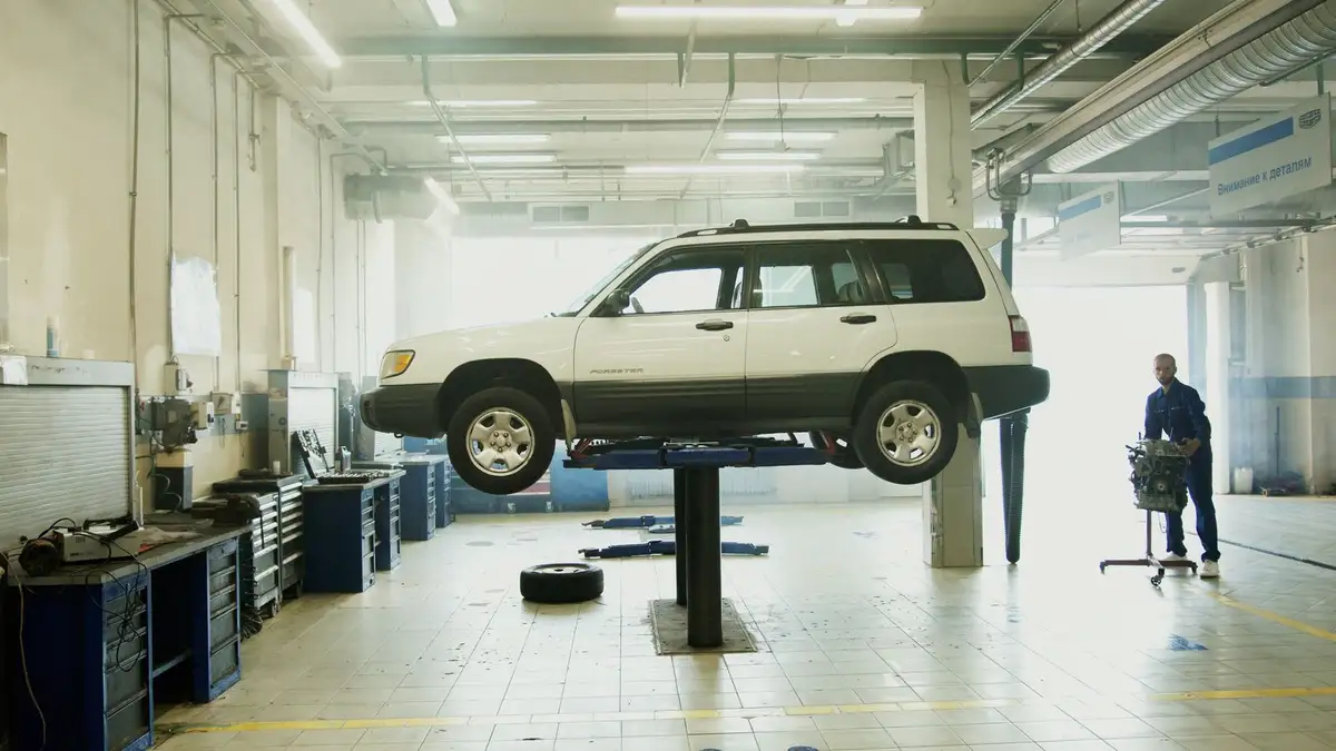 SUV raised on a lift inside a clean, bright repair bay