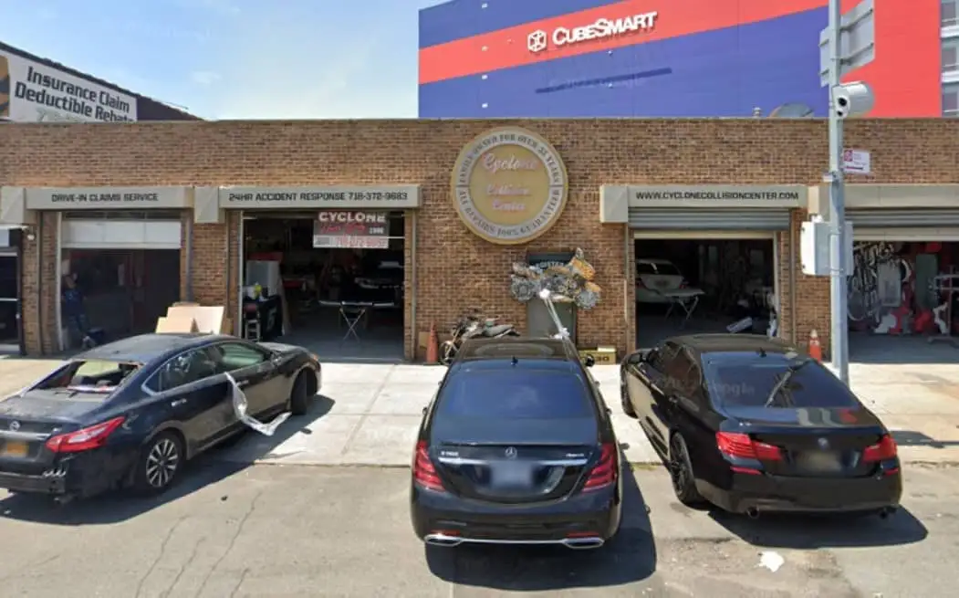 Cyclone Collision Center storefront on Cropsey Avenue with open garage bays and cars parked out front
